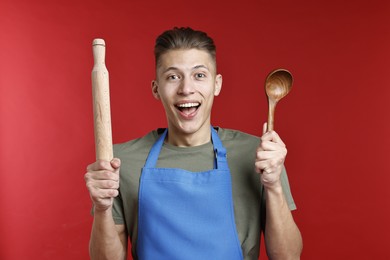 Photo of Man with rolling pin and spoon on red background