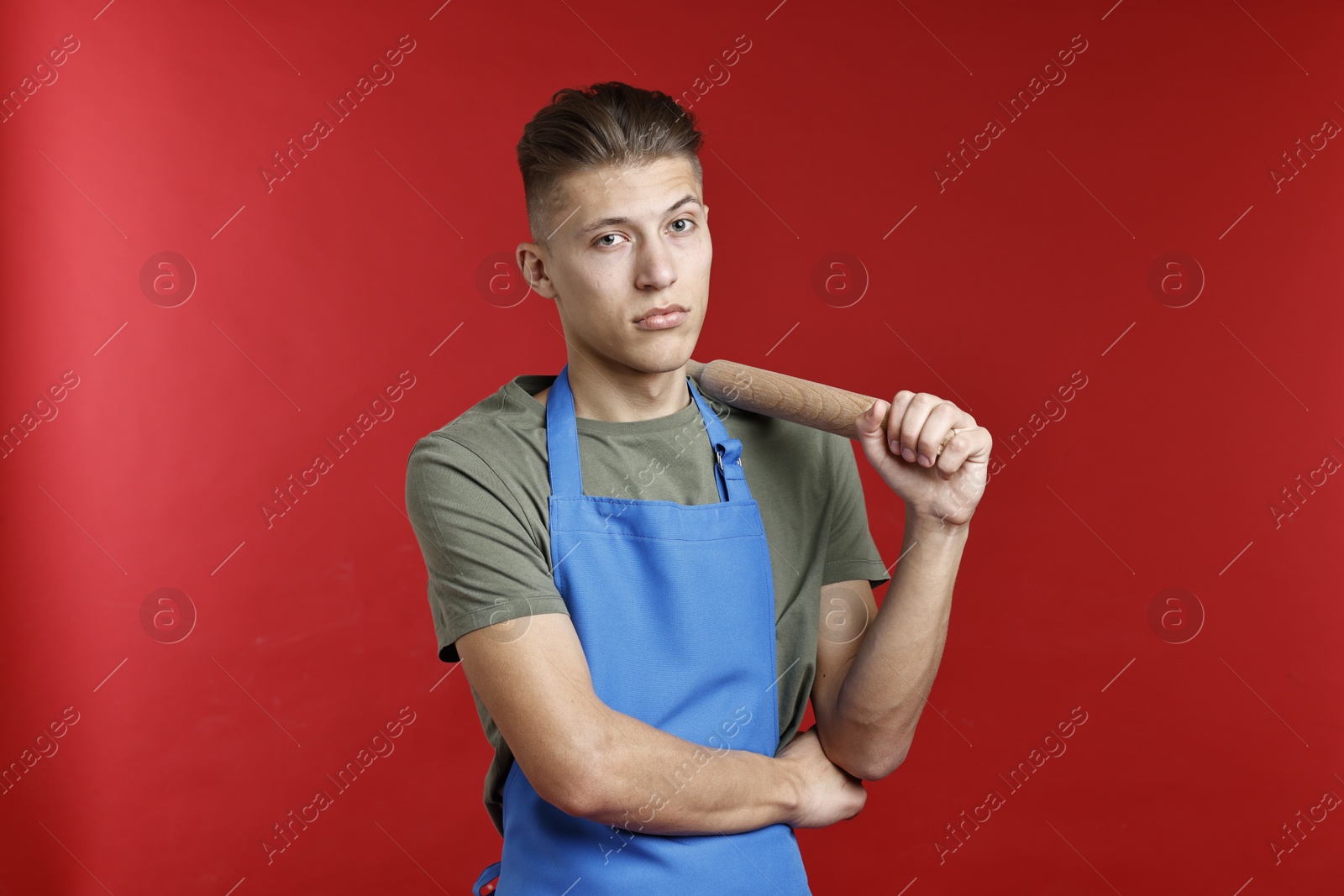 Photo of Man with rolling pin on red background