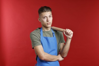 Photo of Man with rolling pin on red background