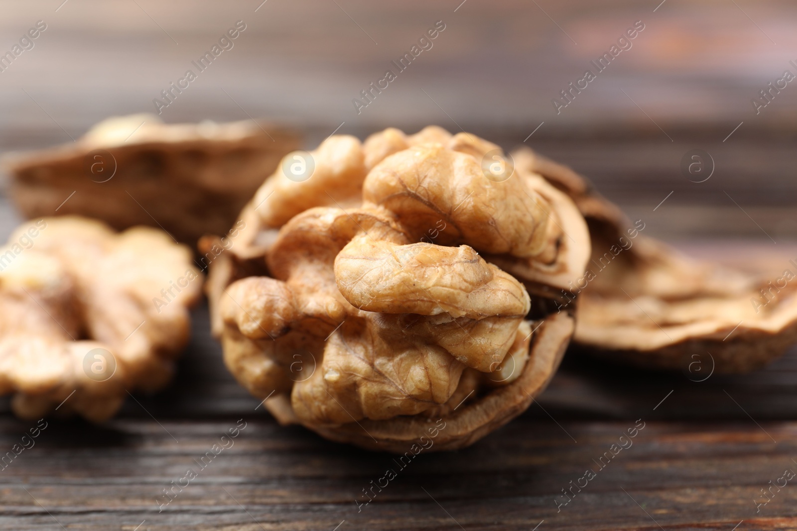 Photo of Fresh walnuts on wooden table, closeup view