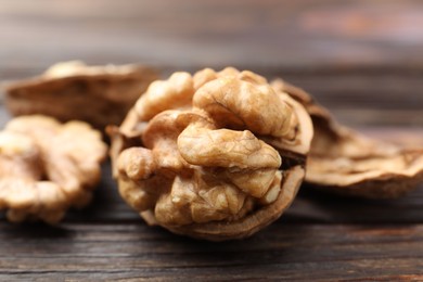 Photo of Fresh walnuts on wooden table, closeup view