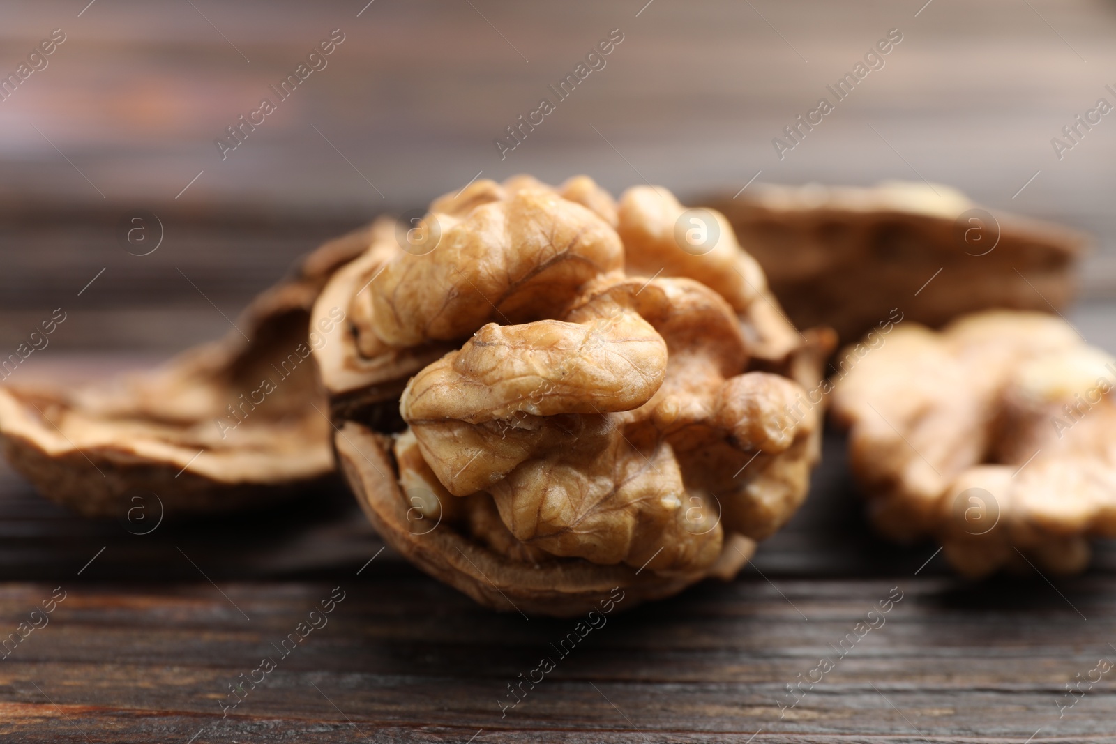 Photo of Fresh walnuts on wooden table, closeup view