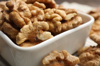 Photo of Peeled walnuts in bowl on table, closeup