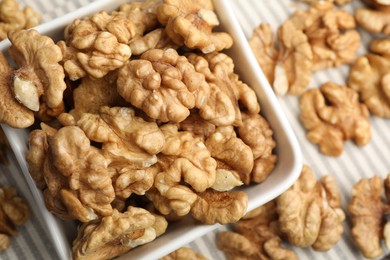 Photo of Peeled walnuts in bowl on table, top view