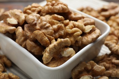 Photo of Peeled walnuts in bowl on table, closeup