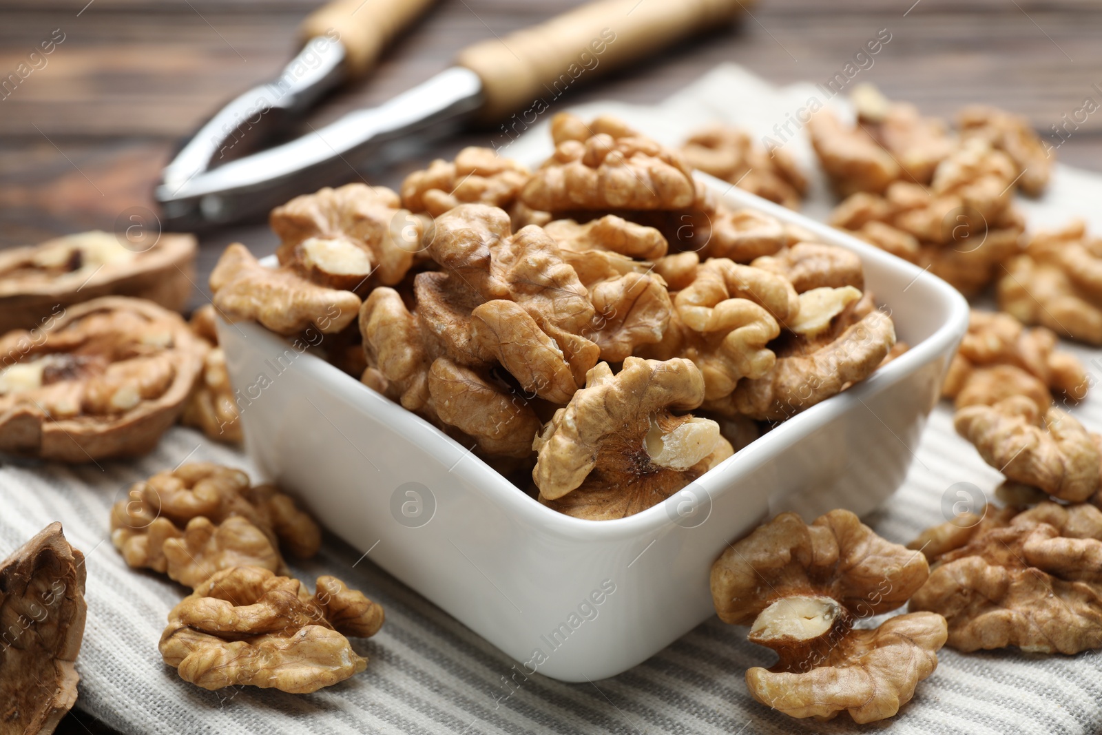 Photo of Peeled walnuts in bowl on table, closeup