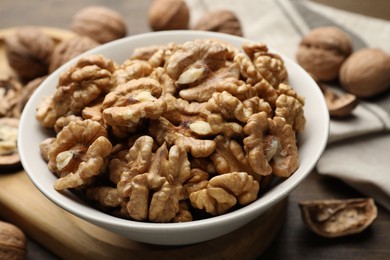 Photo of Peeled walnuts in bowl on table, closeup