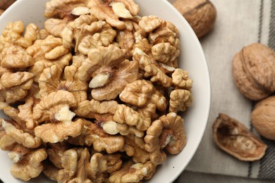 Photo of Peeled walnuts in bowl on table, top view