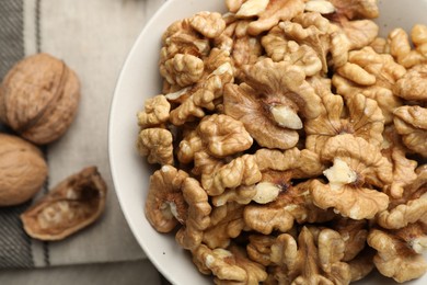 Photo of Peeled walnuts in bowl on table, top view