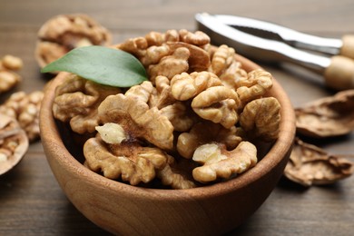 Photo of Peeled walnuts in bowl on table, closeup