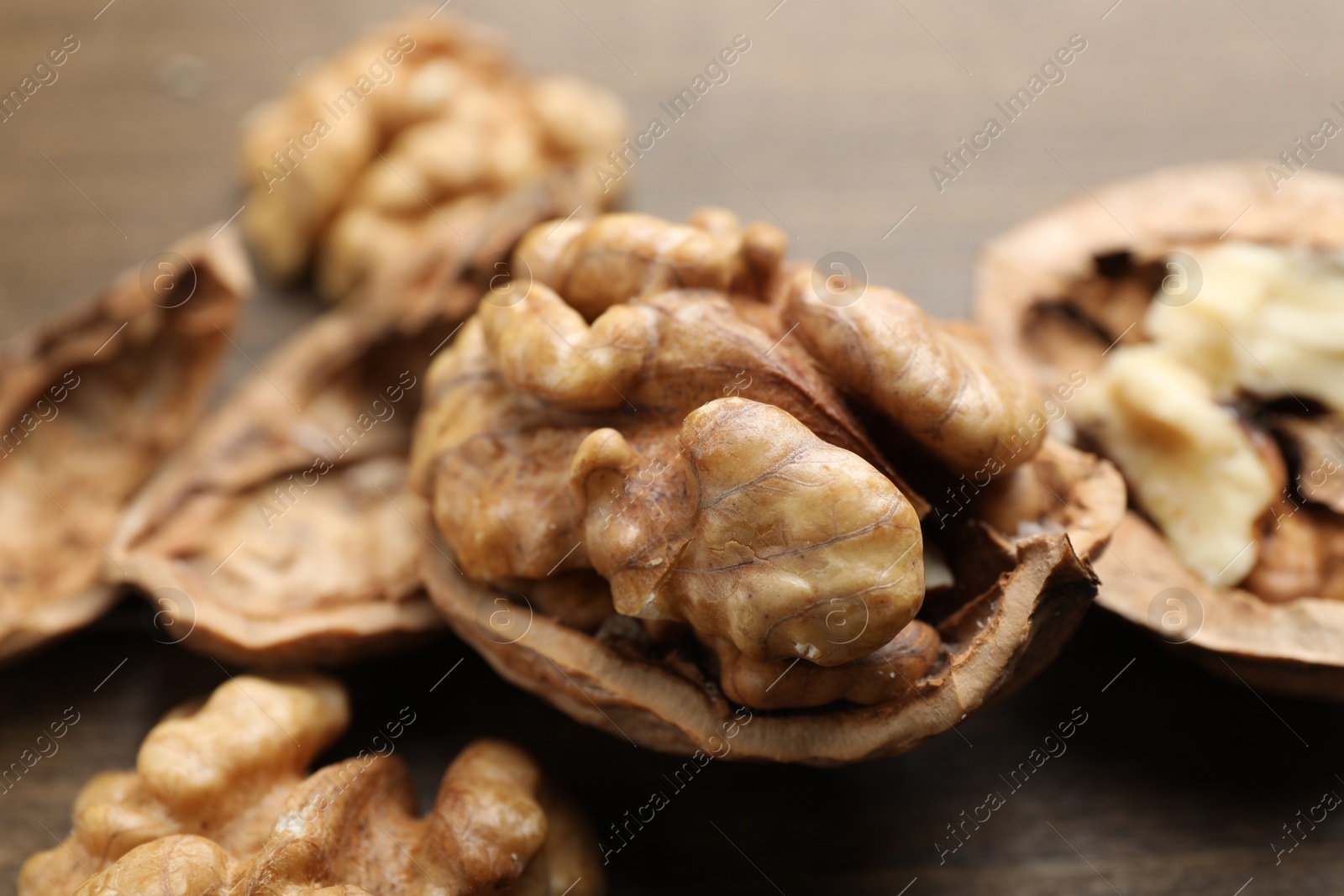 Photo of Fresh walnuts with shells on table, closeup