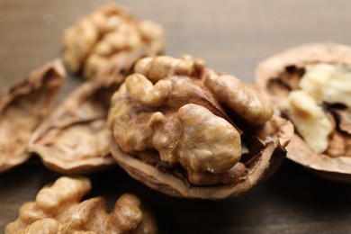 Photo of Fresh walnuts with shells on table, closeup