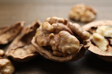 Photo of Fresh walnuts with shells on table, closeup