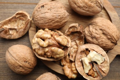 Photo of Fresh walnuts with shells on table, flat lay