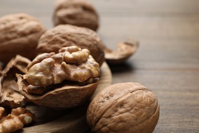 Photo of Fresh walnuts with shells on table, closeup