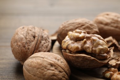 Photo of Fresh walnuts with shells on table, closeup