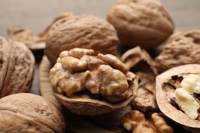 Photo of Fresh walnuts with shells on table, closeup