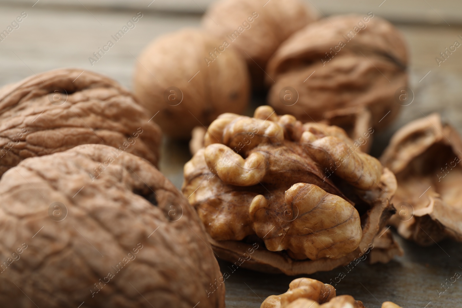 Photo of Fresh walnuts with shells on table, closeup