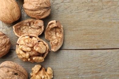 Photo of Fresh walnuts on wooden table, flat lay. Space for text