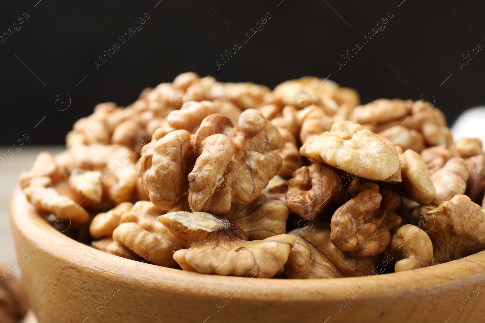 Photo of Peeled walnuts in bowl on table, closeup