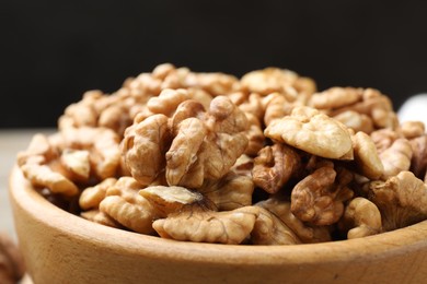 Photo of Peeled walnuts in bowl on table, closeup