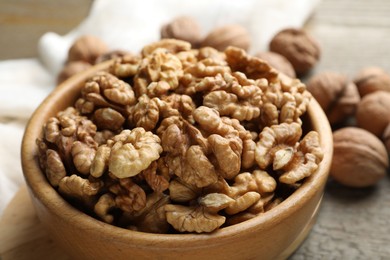 Photo of Peeled walnuts in bowl on table, closeup