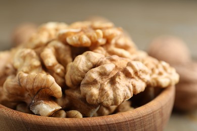 Photo of Peeled walnuts in bowl on table, closeup