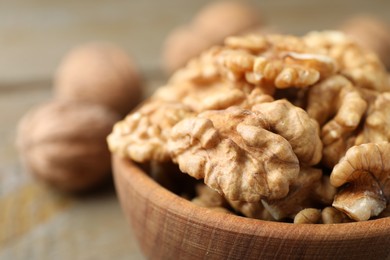 Photo of Peeled walnuts in bowl on table, closeup