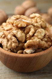 Photo of Peeled walnuts in bowl on table, closeup