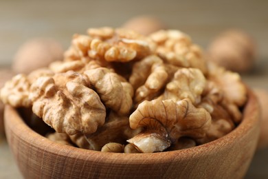 Photo of Peeled walnuts in bowl on table, closeup