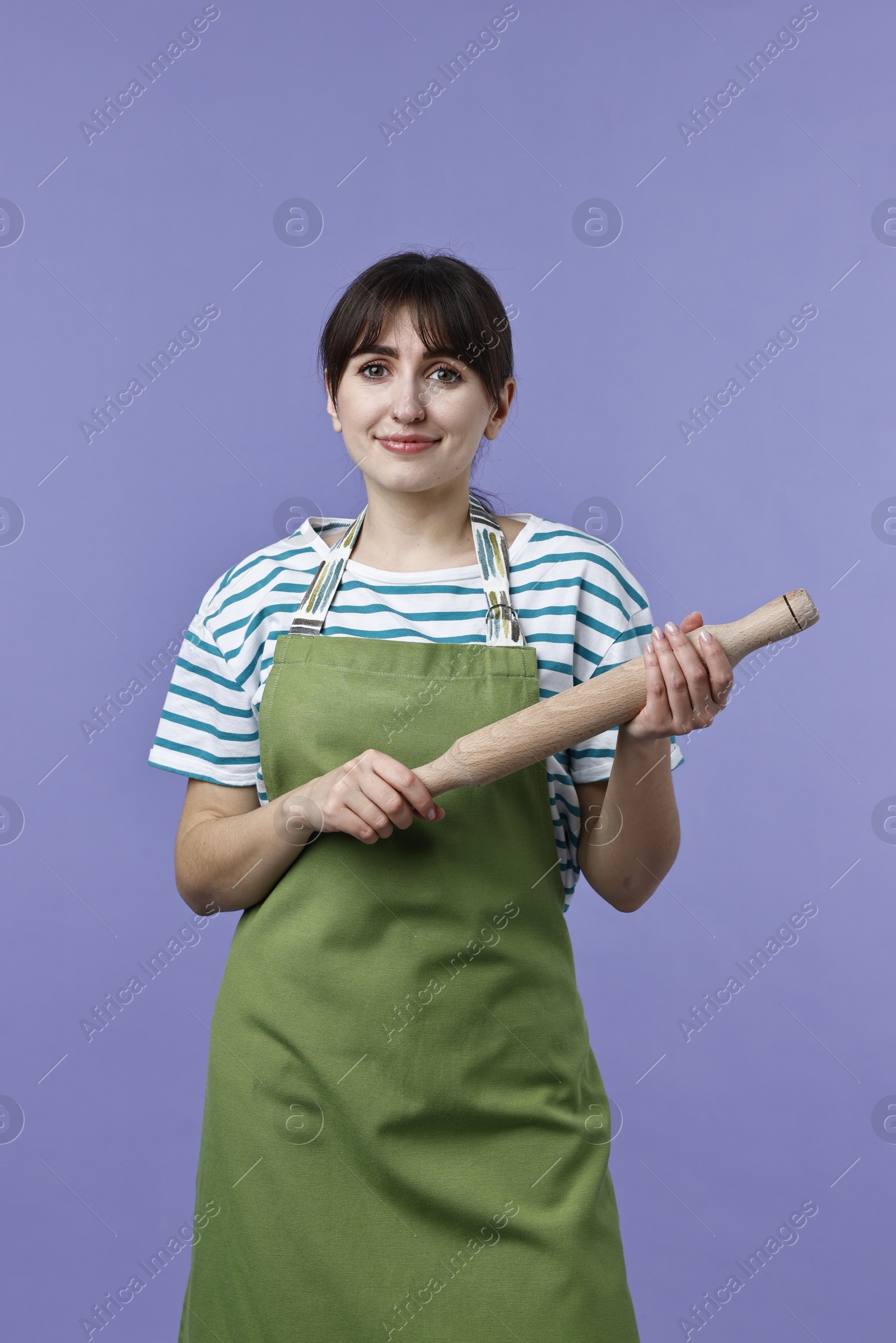 Photo of Woman with rolling pin on violet background