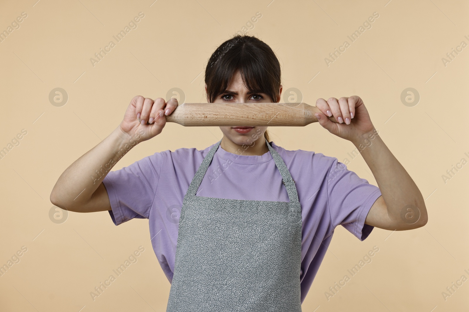 Photo of Woman with rolling pin on beige background