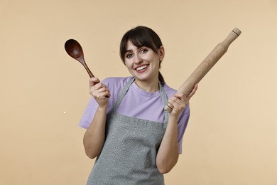 Photo of Woman with rolling pin and spoon on beige background