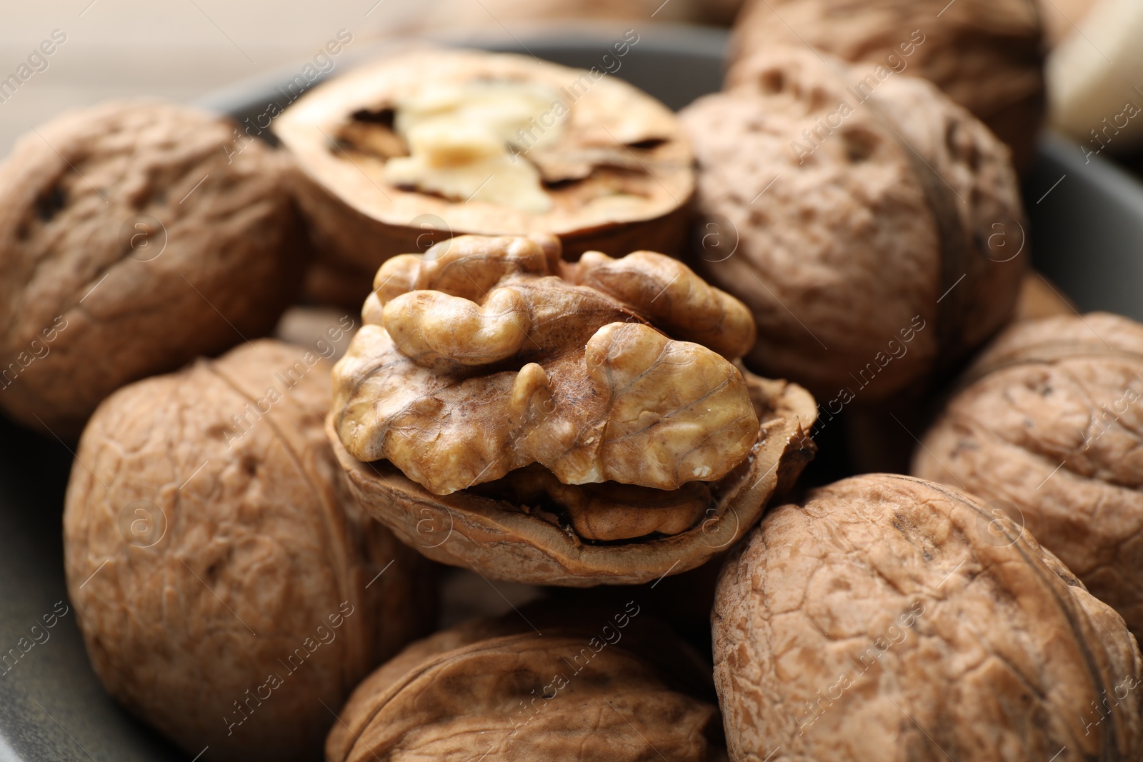 Photo of Fresh walnuts with shells on table, closeup