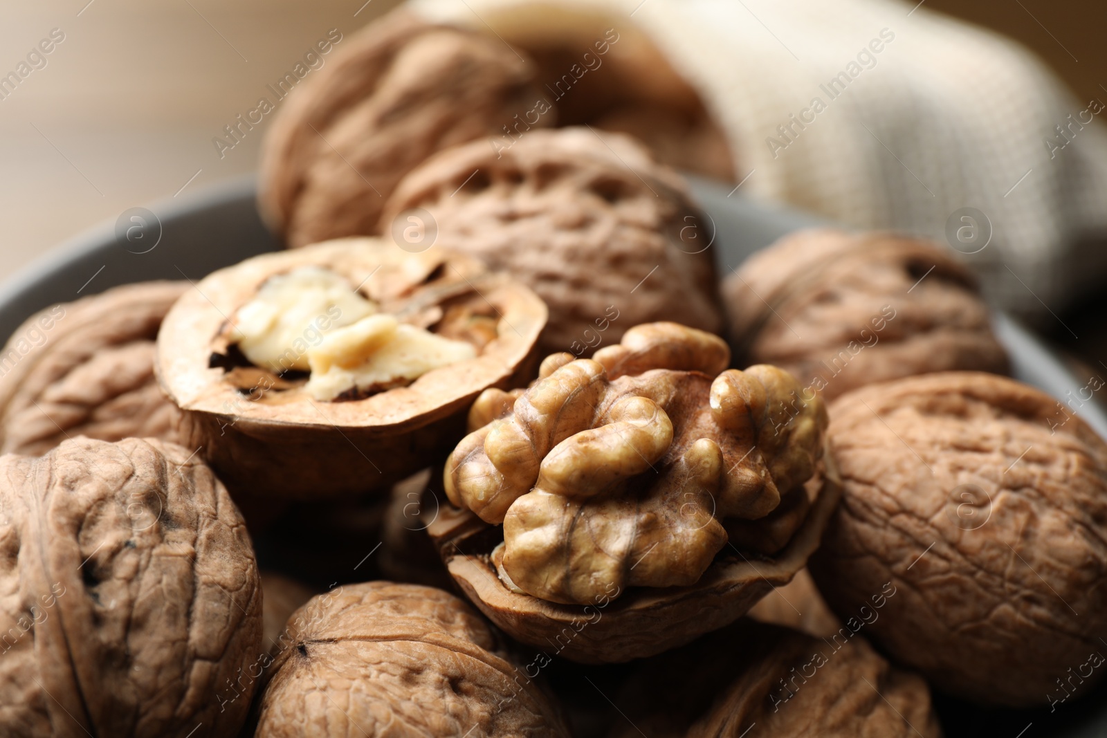 Photo of Fresh walnuts in bowl on table, closeup