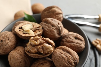 Photo of Fresh walnuts in bowl on table, closeup