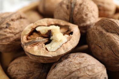 Photo of Fresh walnuts with shells on table, closeup