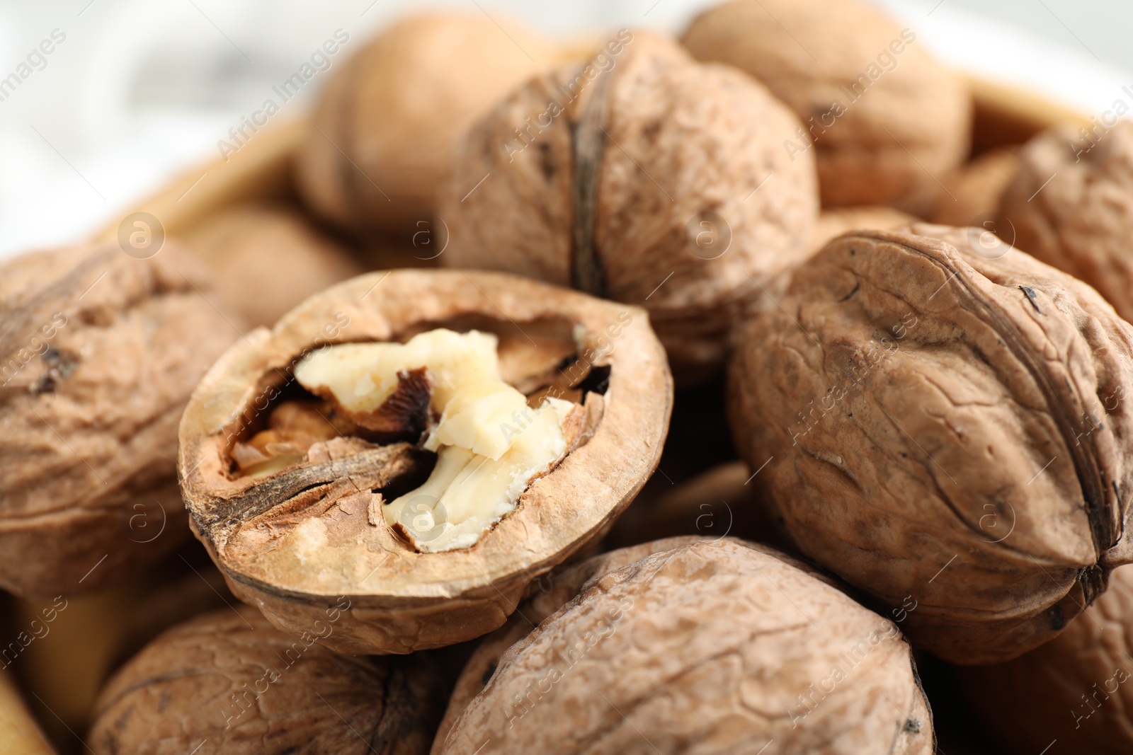 Photo of Fresh walnuts with shells on table, closeup