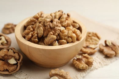 Photo of Peeled walnuts in bowl on light table, closeup