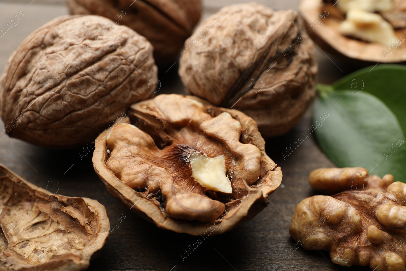 Photo of Fresh walnuts with shells on table, closeup