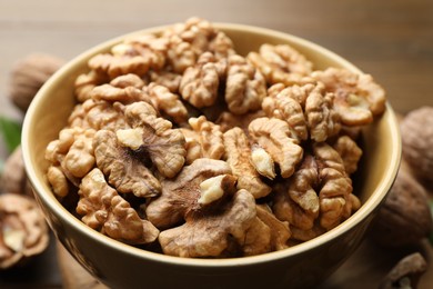 Photo of Peeled walnuts in bowl on table, closeup