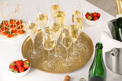 Photo of Champagne, strawberries and canapes with red caviar on white table