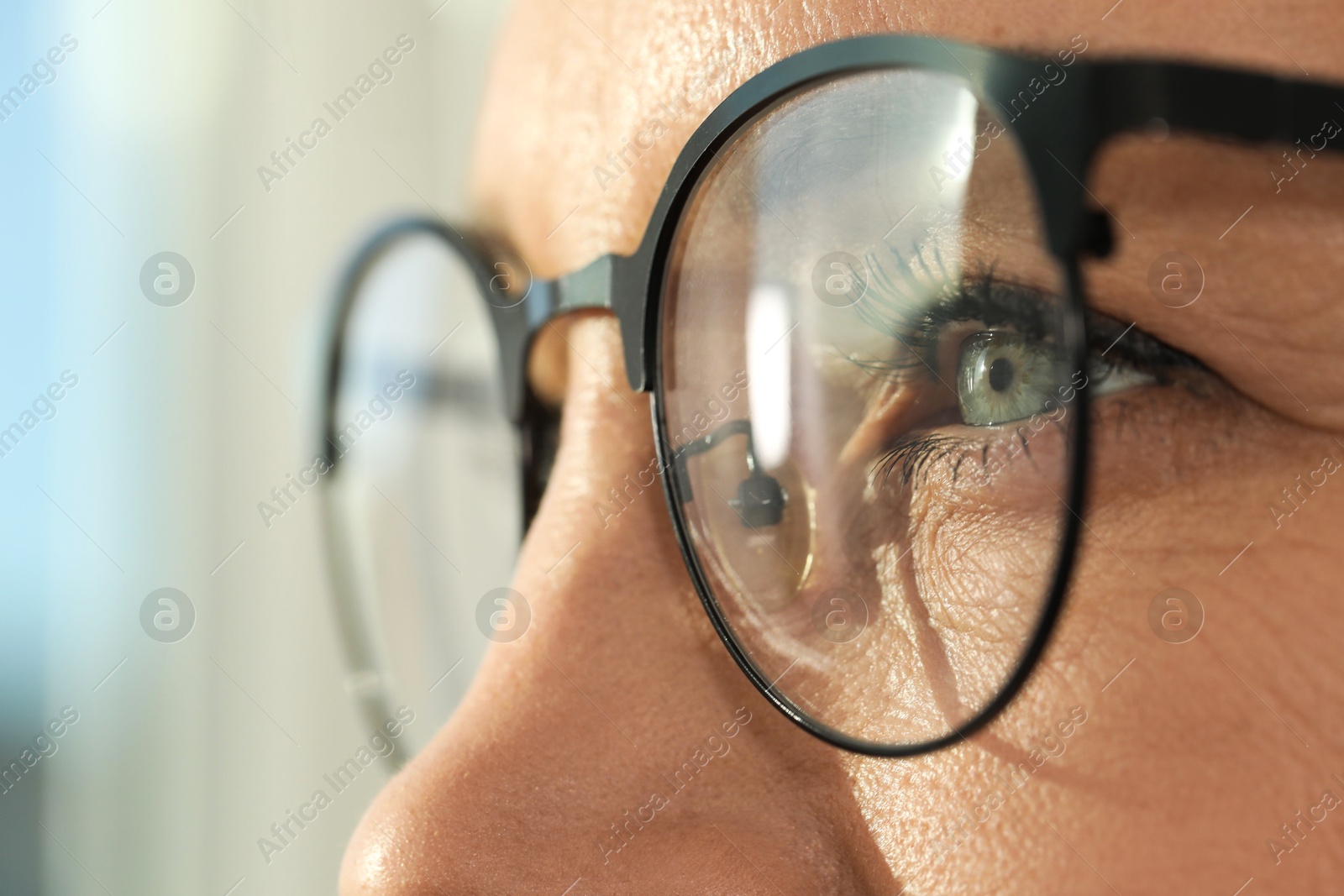 Photo of Woman wearing stylish glasses on blurred background, closeup