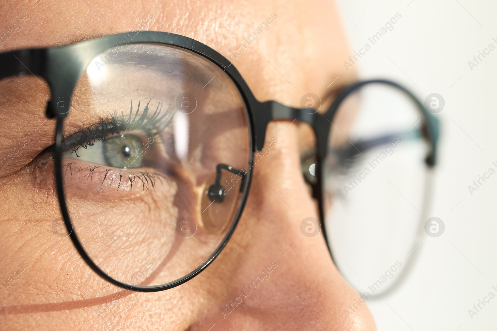 Photo of Woman wearing stylish glasses on blurred background, closeup