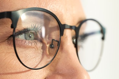 Photo of Woman wearing stylish glasses on blurred background, closeup