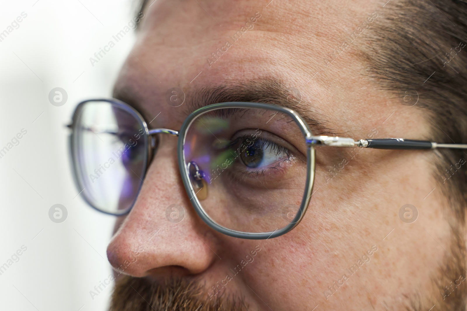 Photo of Man wearing stylish glasses on blurred background, closeup