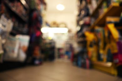 Photo of Blurred view of shelves with different products in pet shop