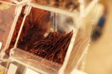 Photo of Display with treats in pet shop, closeup