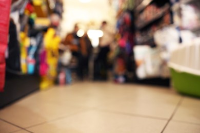 Photo of Blurred view of shelves with different products in pet shop