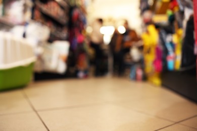 Photo of Blurred view of shelves with different products in pet shop